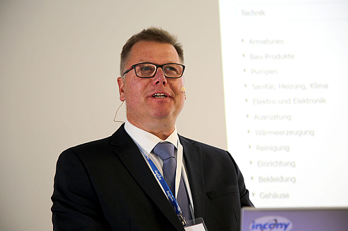 Redner Holger Aisch beim PIM-Forum vor Vortragsfolie